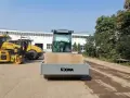 Nowy walec maszyna SOCMA gotowy do pracy na budowie. Obok stoją inne żółte maszyny budowlane.