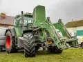 Zielony ciągnik Fendt 714 Vario z ładowaczem czołowym. Dane techniczne tego modelu są imponujące.