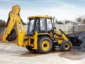 Żółty koparko-ładowarka JCB 3CX, gotowy do pracy. Jego waga pozwala na stabilność podczas kopania.