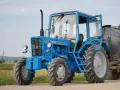 Niebieski ciągnik 4x4 MTZ-82 "Biełaruś" z otwartymi drzwiami, gotowy do pracy w polu. Idealny ciągnik 4x4 do 30 tys.