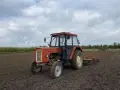 Pomarańczowy Ursus C-360 na polu, gotowy do pracy. Warto sprawdzić, ile oleju do silnika C-360 wlać przed sezonem.