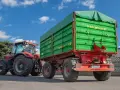 Czerwony traktor z zieloną przyczepą rolniczą. Czy przyczepa rolnicza musi być zarejestrowana? Sprawdź przepisy!