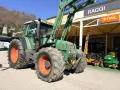 Zielony traktor Fendt 716 z ładowaczem, obok sklepu Raggi. Dane techniczne tego modelu są imponujące.
