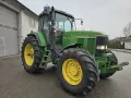 Zielony traktor John Deere 7600, gotowy do pracy. Dane techniczne tego modelu to potęga i niezawodność.