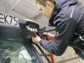 Mężczyzna montuje lampy LED na ciągniku. Dowiedz się, jak podłączyć lampy LED w ciągniku, aby poprawić widoczność w nocy.