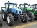 Rząd nowoczesnych traktorów: niebieski New Holland, zielony Deutz-Fahr i żółty Claas. Zastanawiasz się, ile motogodzin to dużo dla takiej maszyny?