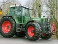 Zielony traktor Fendt 615 LSA z czerwonymi felgami, gotowy do pracy. Poznaj jego dane techniczne!