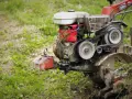 Glebogryzarka separacyjna w akcji. Silnik pracuje, pasy się kręcą, a noże rozdrabniają ziemię.