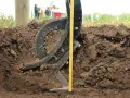Czarne, metalowe elementy podeszwy płużnej zagłębiają się w ziemi. Obok miarka pokazuje głębokość orki.