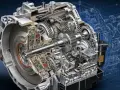 Przekładnia automatyczna w przekroju, ukazująca skomplikowane mechanizmy i koła zębate. Widoczne są elementy sterujące i hydrauliczne, które umożliwiają płynną zmianę **półbiegów**.