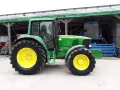 Zielony traktor John Deere 6820, z żółtymi felgami, gotowy do pracy. Dane techniczne tego modelu są imponujące.
