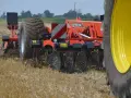 Maszyna rolnicza wykonuje bronowanie po orce, spulchniając ziemię i przygotowując pole do siewu.