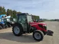 Czerwony ciągnik Massey Ferguson 3650 S Xtra, z kabiną, zaparkowany na placu z innymi maszynami. Dane techniczne tego modelu są imponujące.