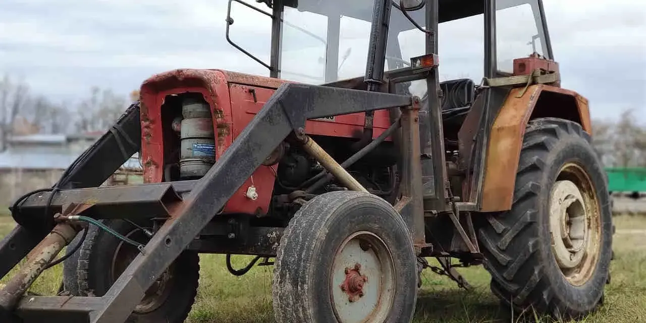 Czerwony traktor Ursus C-360 z ładowaczem. Zbiornik paliwa C-360 pojemność jest kluczowa dla długiej pracy w polu.