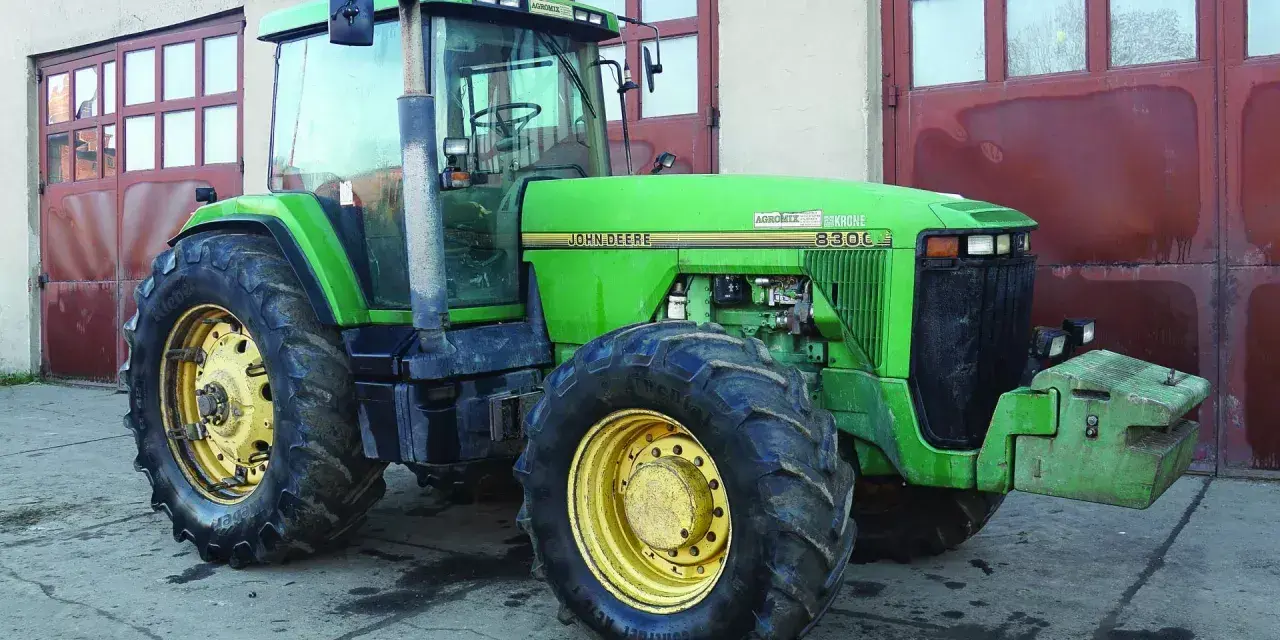 Zielony John Deere 8300C, potężna maszyna rolnicza, gotowa do pracy. Zastanawiasz się, ile motogodzin wytrzyma ciągnik tej klasy?