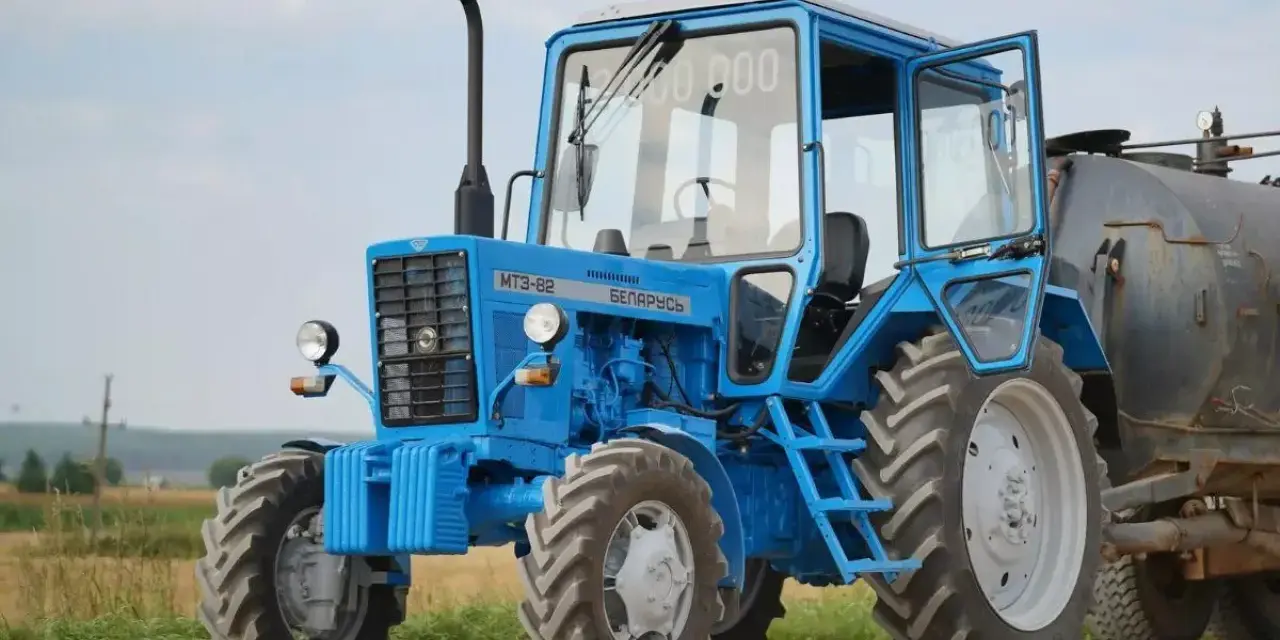 Niebieski ciągnik 4x4 MTZ-82 "Biełaruś" z otwartymi drzwiami, gotowy do pracy w polu. Idealny ciągnik 4x4 do 30 tys.