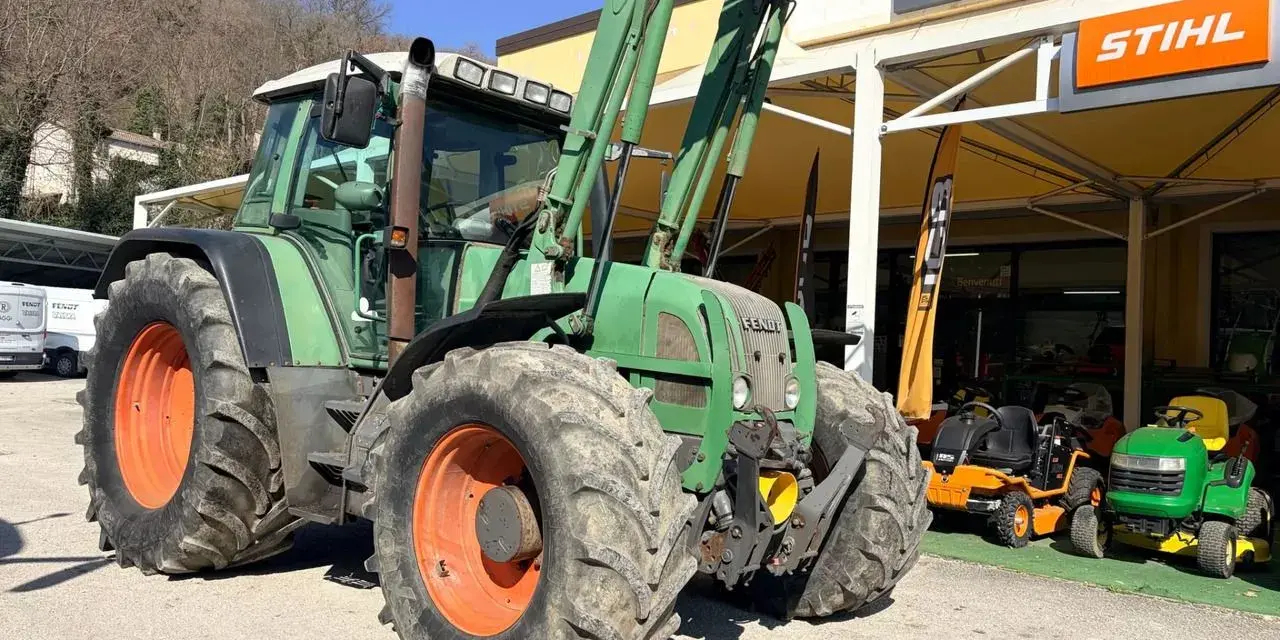 Zielony traktor Fendt 716 z ładowaczem, obok sklepu Raggi. Dane techniczne tego modelu są imponujące.
