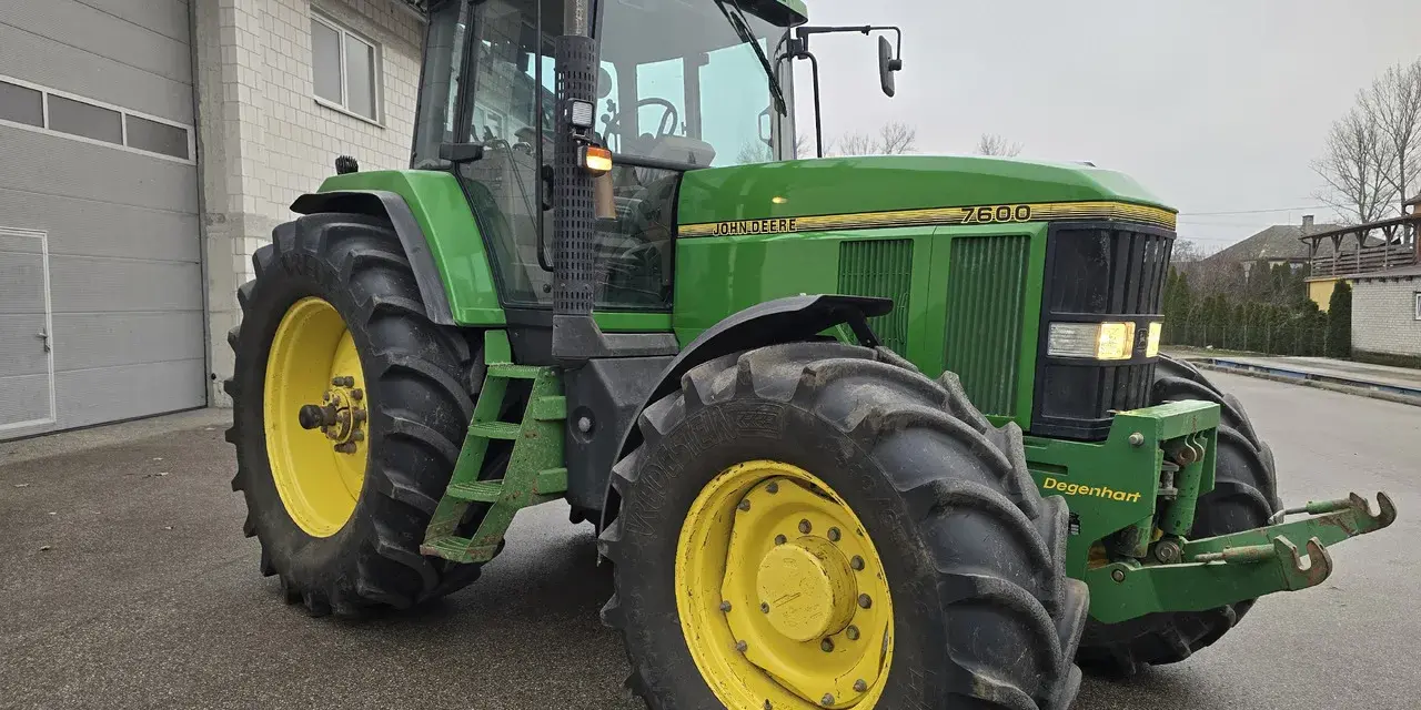 Zielony traktor John Deere 7600, gotowy do pracy. Dane techniczne tego modelu to potęga i niezawodność.