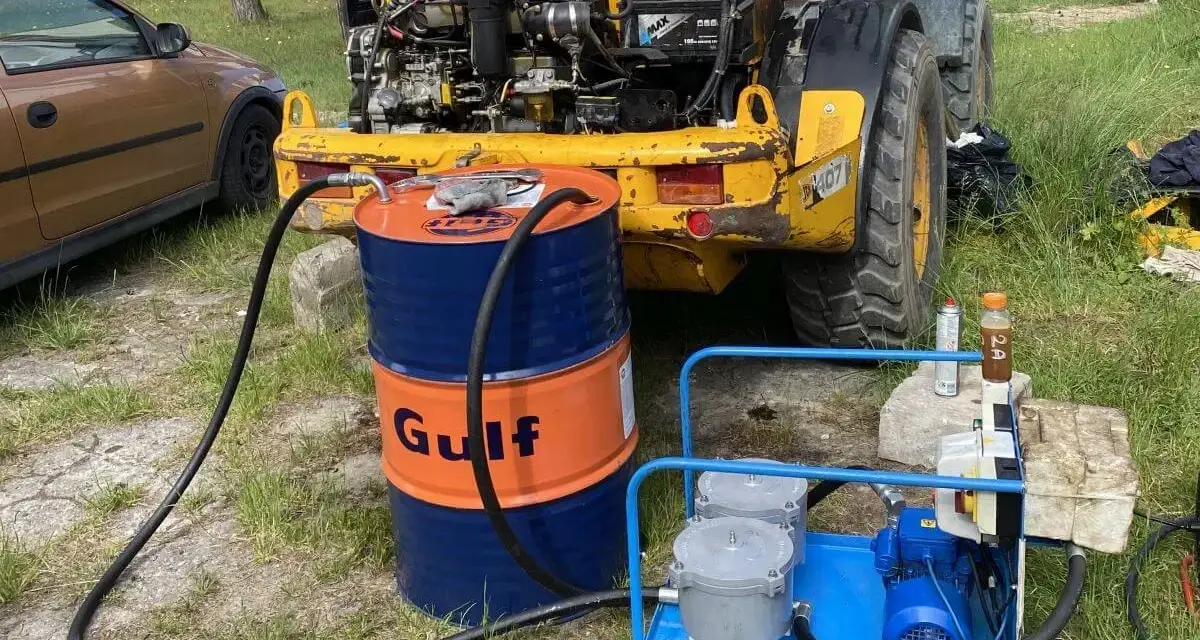 Ważne jest, jak sprawdzić poziom oleju hydraulicznego w koparce. Na zdjęciu widać beczkę Gulf i pompę do uzupełniania płynu.