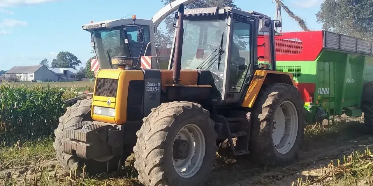 Żółty ciągnik Renault 120.54 z przyczepą podczas żniw kukurydzy. Pytanie o jaki olej do silnika MWM Renault jest tu na miejscu.
