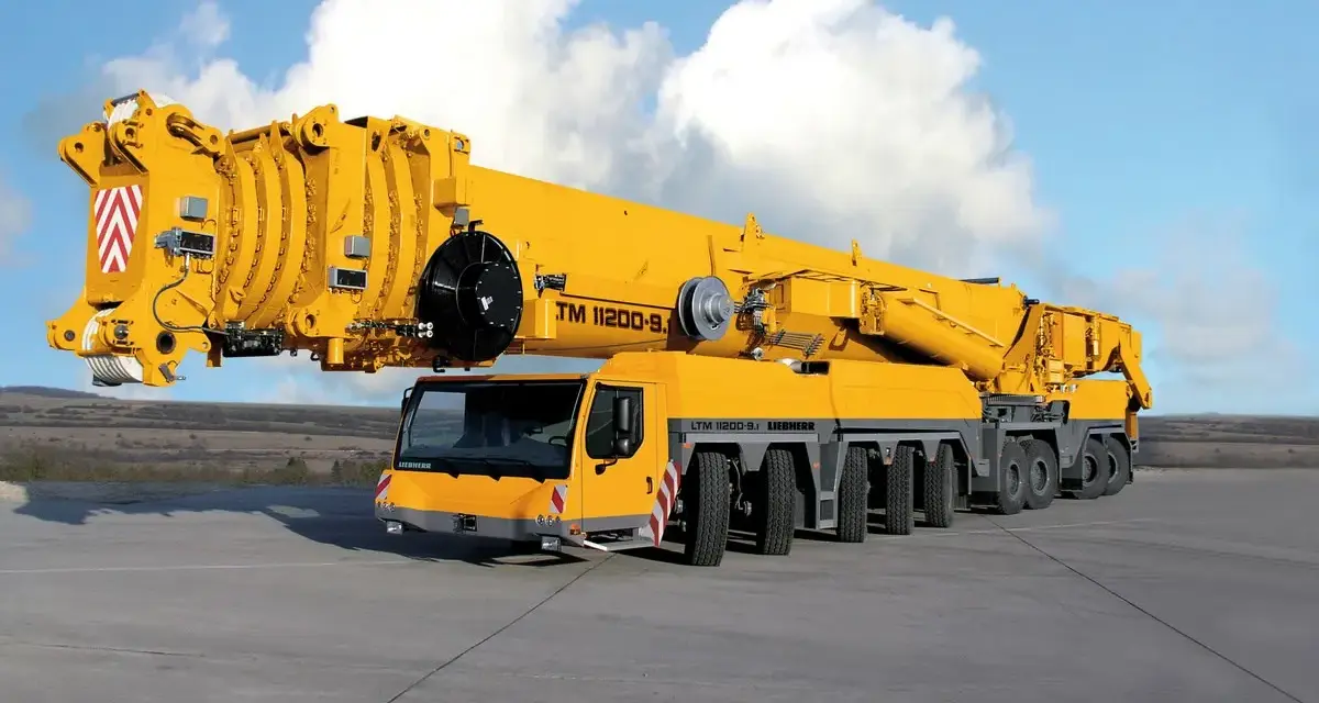 Potężny, żółty dźwig LTM 11200-9.1 o udźwigu 1200 ton, gotowy do pracy.