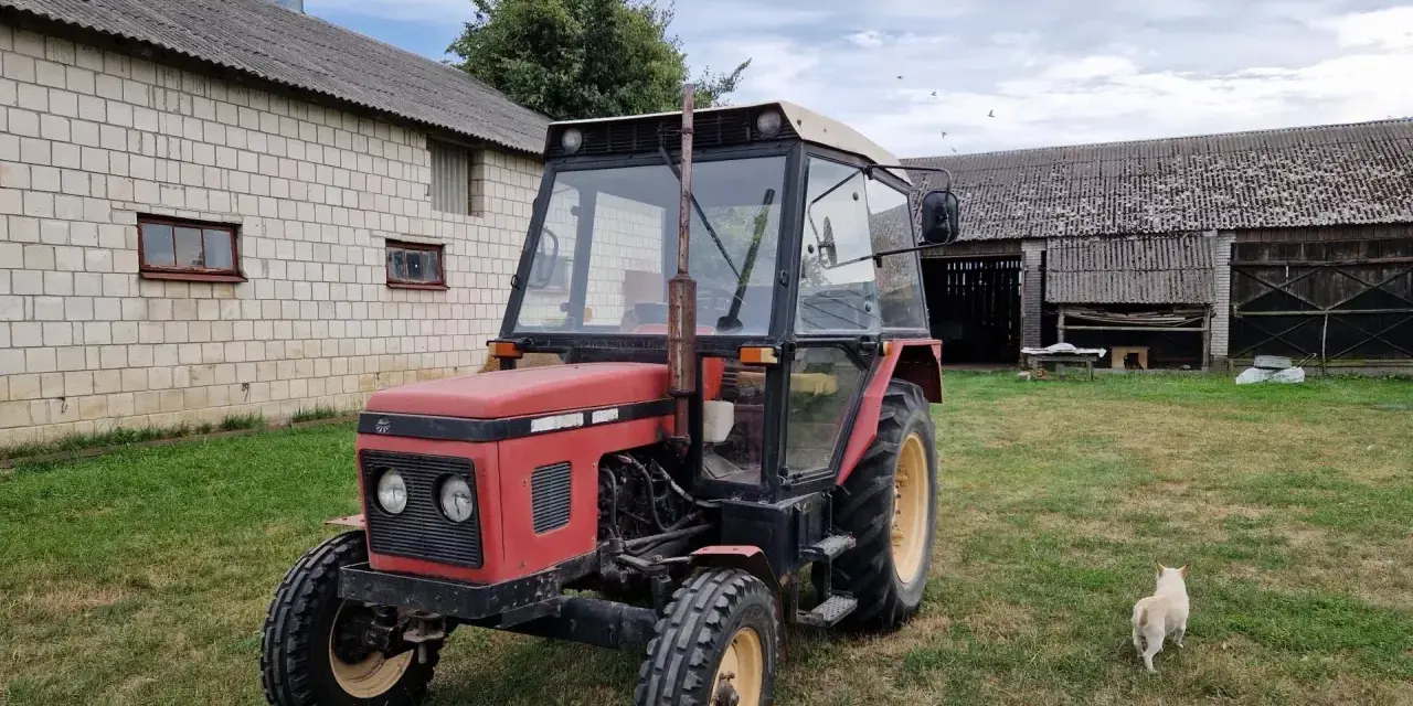 Czerwony Zetor 5011 na trawie, obok budynków gospodarczych. Zastanawiasz się nad jego spalaniem?