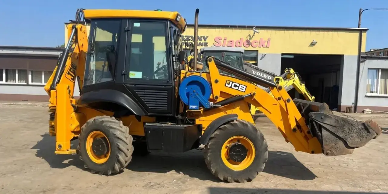 Żółta koparko-ładowarka JCB 2CX z ładowarką z przodu i koparką z tyłu, gotowa do pracy. Dane techniczne dostępne dla zainteresowanych.