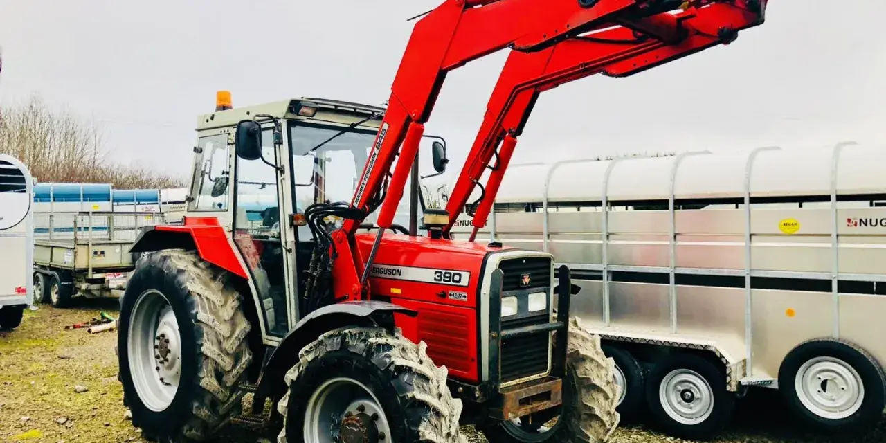 Czerwony ciągnik Massey Ferguson 390 z ładowaczem czołowym, gotowy do pracy. Dane techniczne tego modelu są imponujące.