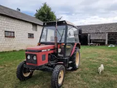 Czerwony Zetor 5011 na trawie, obok budynków gospodarczych. Zastanawiasz się nad jego spalaniem?