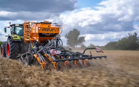 Traktor z siewnikiem Mzuri Select pracuje na polu, wykonując uprawę bezorkową. To idealny agregat do siewu bezpośredniego.