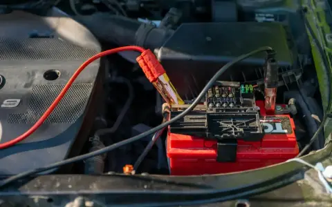 Kable rozruchowe podłączone do akumulatora. Czerwony kabel z zaciskiem na biegunie, czarny na skrzynce bezpieczników. Odpalanie na krótko.