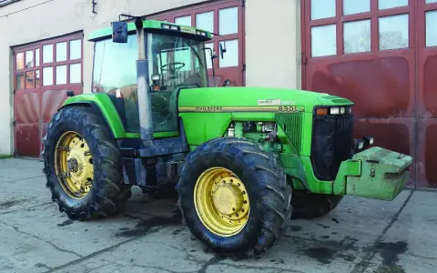 Zielony John Deere 8300C, potężna maszyna rolnicza, gotowa do pracy. Zastanawiasz się, ile motogodzin wytrzyma ciągnik tej klasy?