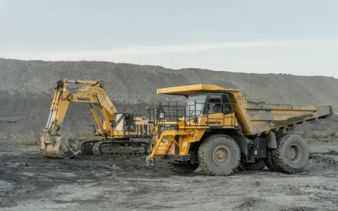 Żółty koparka i wywrotka Komatsu na placu budowy. Poznaj nazwy maszyn budowlanych, które pracują w trudnych warunkach.