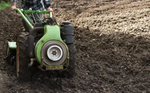 Rolnik używa jednoosiowego ciągnika z pługiem do orki. Różne rodzaje pługów pomagają przygotować ziemię pod uprawę.