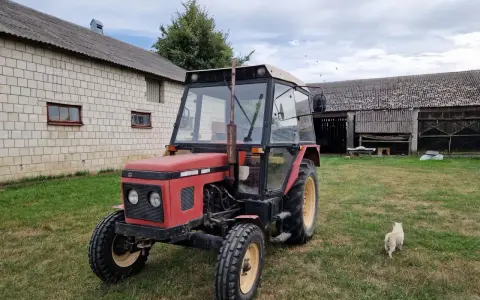 Czerwony Zetor 5011 na trawie, obok budynków gospodarczych. Zastanawiasz się nad jego spalaniem?
