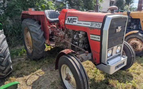 Czerwony Massey Ferguson 235, gotowy do pracy. Dane techniczne tego modelu to jego moc i niezawodność.