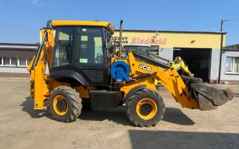 Żółta koparko-ładowarka JCB 2CX z ładowarką z przodu i koparką z tyłu, gotowa do pracy. Dane techniczne dostępne dla zainteresowanych.