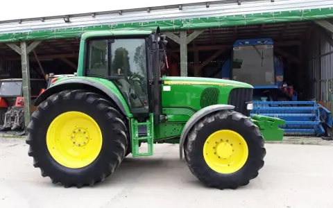 Zielony traktor John Deere 6820, z żółtymi felgami, gotowy do pracy. Dane techniczne tego modelu są imponujące.