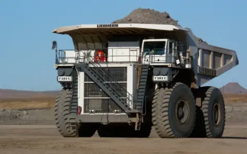 Ogromna kopalniana ciężarówka Liebherr T 282 C, największa maszyna na świecie, z pełnym ładunkiem ziemi.