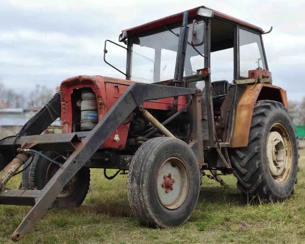 Czerwony traktor Ursus C-360 z ładowaczem. Zbiornik paliwa C-360 pojemność jest kluczowa dla długiej pracy w polu.