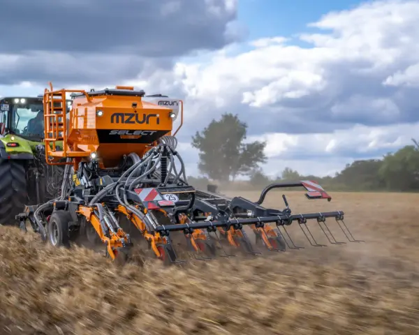 Traktor z siewnikiem Mzuri Select pracuje na polu, wykonując uprawę bezorkową. To idealny agregat do siewu bezpośredniego.