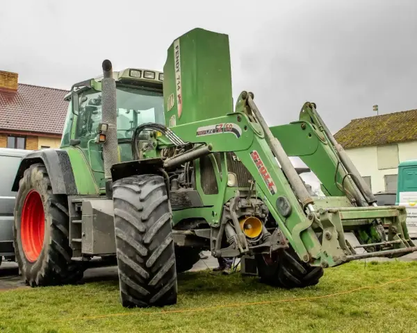 Zielony ciągnik Fendt 714 Vario z ładowaczem czołowym. Dane techniczne tego modelu są imponujące.