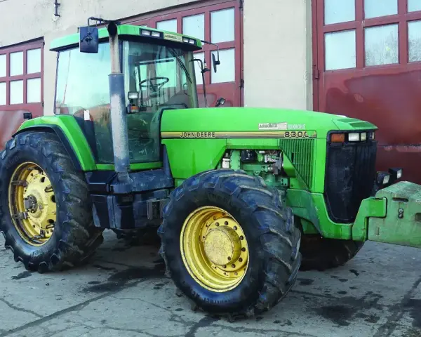 Zielony John Deere 8300C, potężna maszyna rolnicza, gotowa do pracy. Zastanawiasz się, ile motogodzin wytrzyma ciągnik tej klasy?