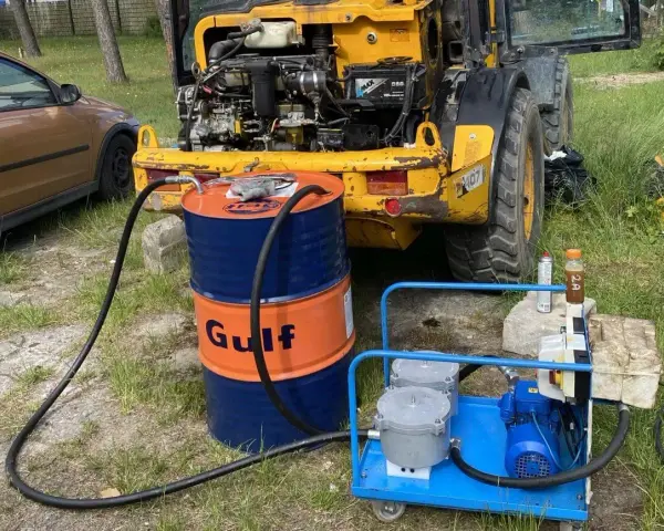 Ważne jest, jak sprawdzić poziom oleju hydraulicznego w koparce. Na zdjęciu widać beczkę Gulf i pompę do uzupełniania płynu.