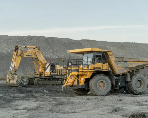 Żółty koparka i wywrotka Komatsu na placu budowy. Poznaj nazwy maszyn budowlanych, które pracują w trudnych warunkach.