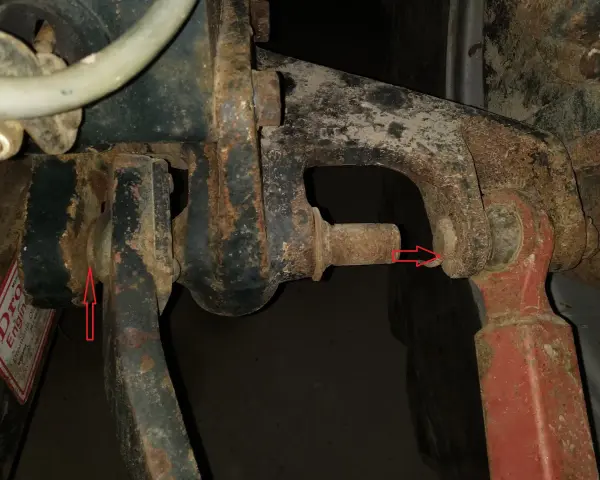 Zetor 7211: gdzie jest filtr hydrauliki? Widoczne elementy układu podnośnika, czerwone strzałki wskazują punkty mocowania.