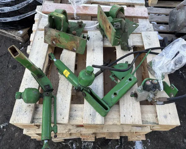 Części do amortyzacji kabiny John Deere: siłownik, wsporniki i elementy hydrauliczne.
