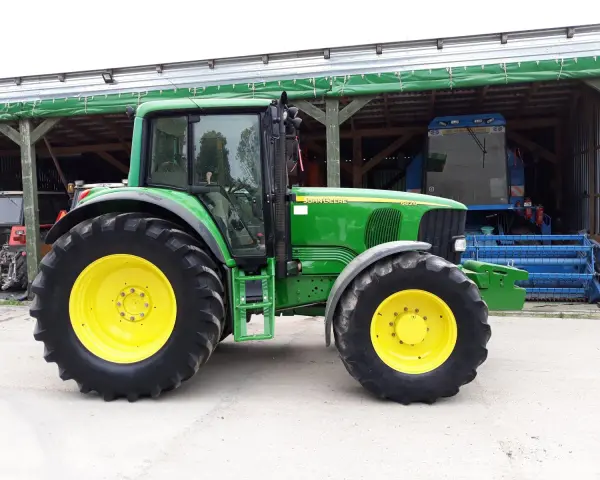 Zielony traktor John Deere 6820, z żółtymi felgami, gotowy do pracy. Dane techniczne tego modelu są imponujące.