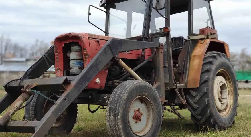 Czerwony traktor Ursus C-360 z ładowaczem. Zbiornik paliwa C-360 pojemność jest kluczowa dla długiej pracy w polu.