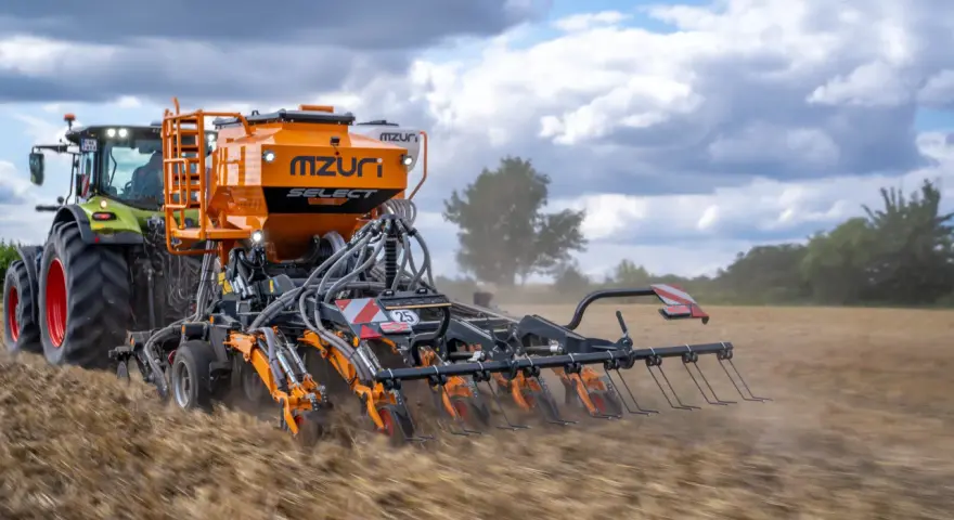 Traktor z siewnikiem Mzuri Select pracuje na polu, wykonując uprawę bezorkową. To idealny agregat do siewu bezpośredniego.